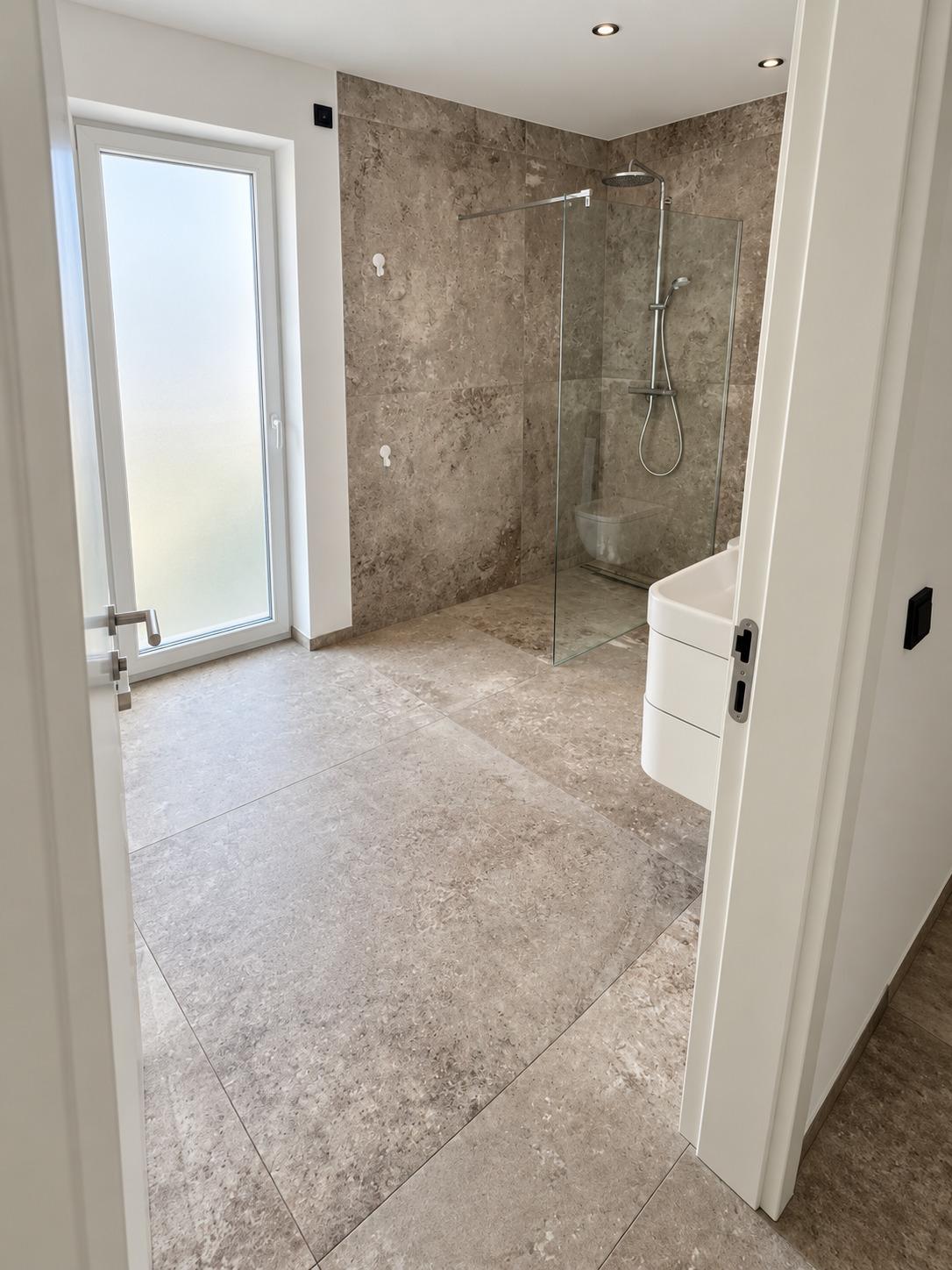 Tageslichtbad mit bodengleicher Walk-in-Dusche hinter Glaswand