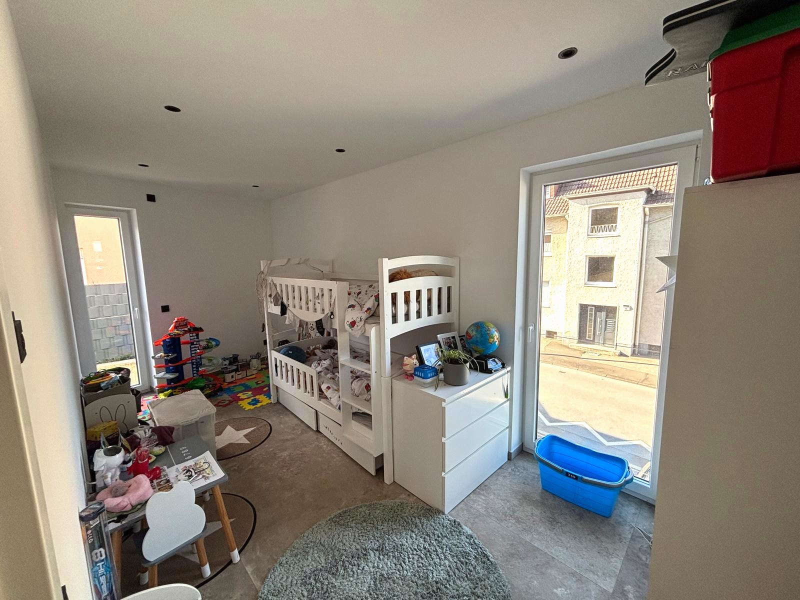 Zweites Zimmer mit bodentiefen Fenstern