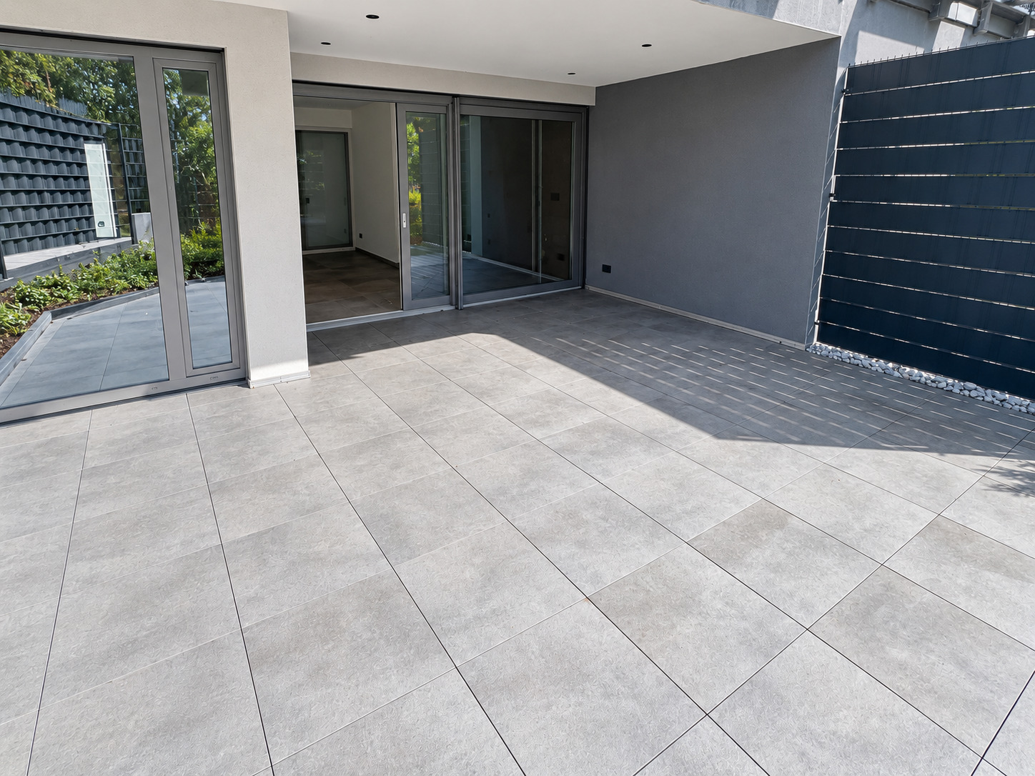 Weitläufige Süd-Terrasse mit überdachtem Bereich und Sichtschutz